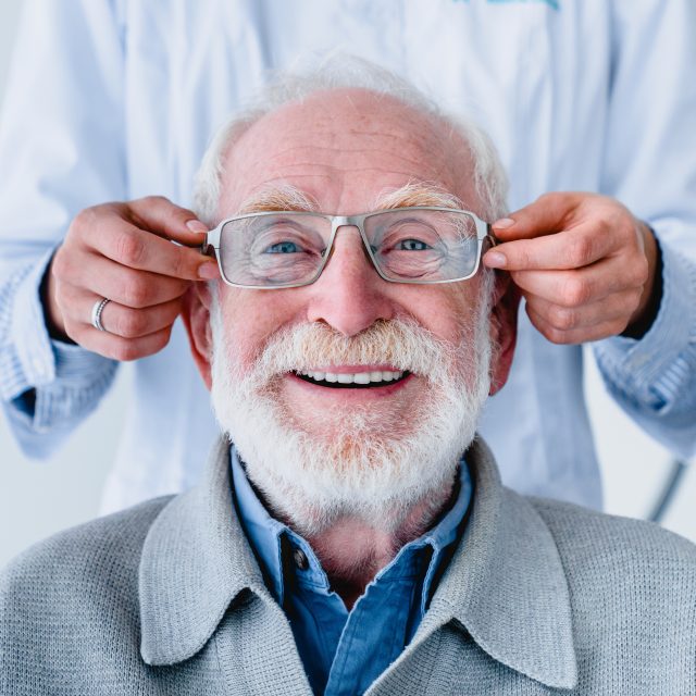 fitting glasses on cheerful senior man 640x640 1