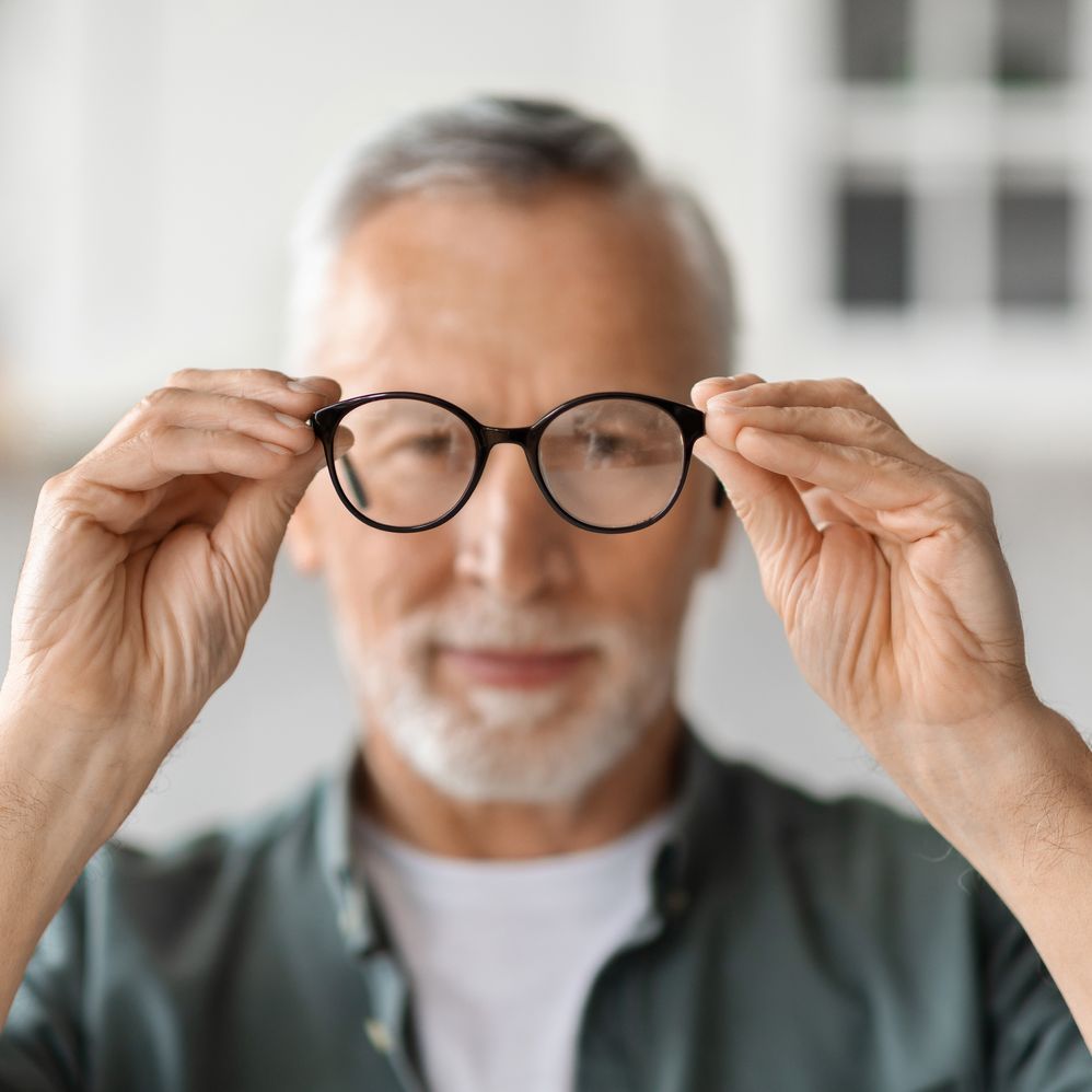senior man looking at eye glasses